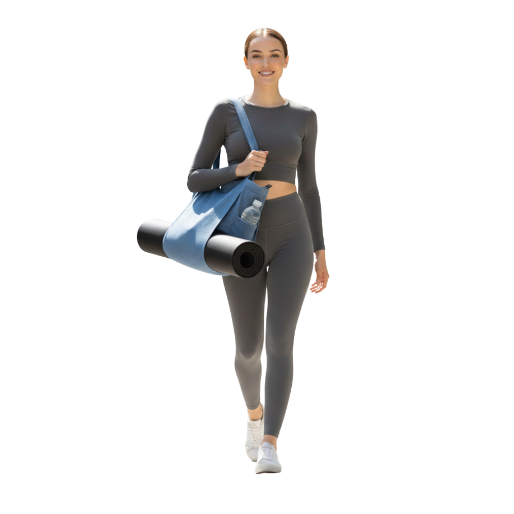 Woman in gray athletic wear holding a denim yoga bag and black mat on a white background