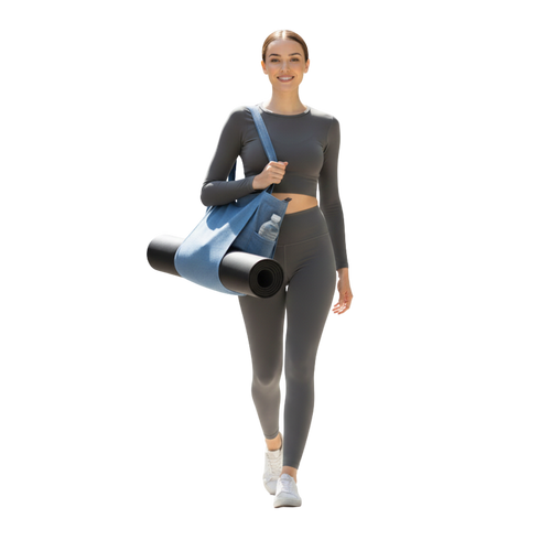 Woman in gray athletic wear holding a denim yoga bag and black mat on a white background